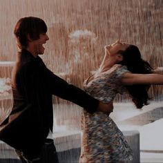 a man and woman dancing in the rain