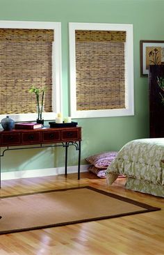 a bedroom with green walls and bamboo blinds