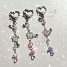 three charms with hearts and stars hanging from them