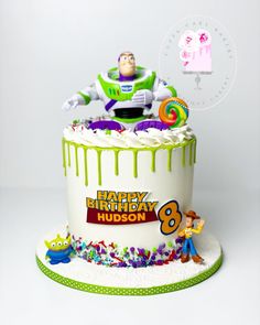 a toy story birthday cake with buzz lightyear figure on top and sprinkles