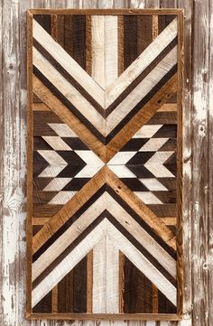 a wooden wall hanging on the side of a building with white and brown wood strips