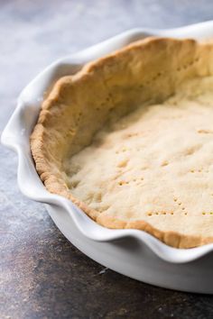 an uncooked pie crust in a white dish