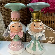 two ceramic figurines sitting next to each other on a table