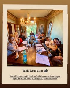 a group of people sitting around a wooden table