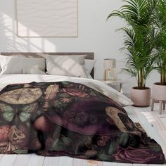 a bed with a blanket on top of it next to a potted palm tree