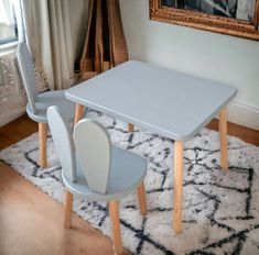 a table and two chairs sitting on top of a rug