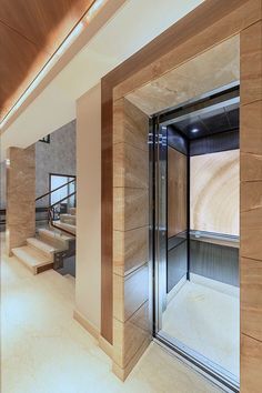 the interior of a modern building with wooden walls and stairs leading up to an elevator