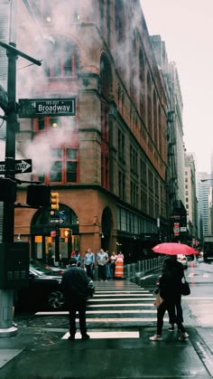 people crossing the street with umbrellas on a rainy day