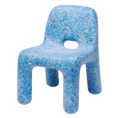 a blue plastic chair sitting on top of a white floor covered in lots of small speckles