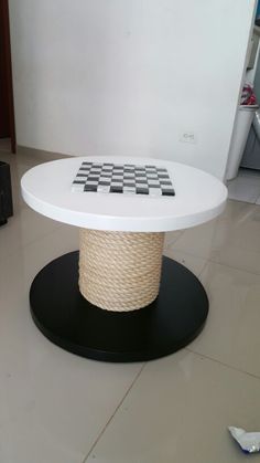 a white table with black and white chess board on it's top, sitting in the middle of a room