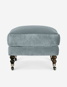 the footstool in blue velvet with wooden legs