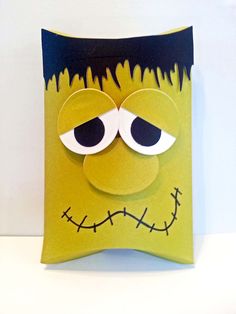 a paper bag with a green monster face on it's front and black eyes