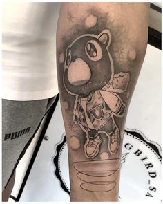 a man's leg with a cartoon character tattoo on it and an image of a bear