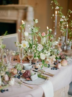 the table is set with flowers, candles and wine glasses for an elegant wedding reception