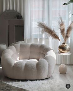 a white chair sitting on top of a rug next to a window