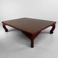 a wooden coffee table with two legs and a square shaped top, on a white background