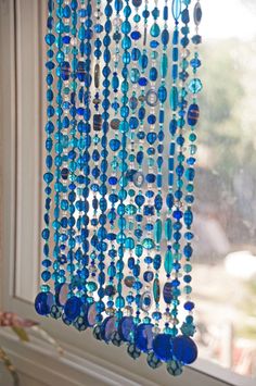 blue beads hanging from the side of a window