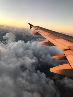 the wing of an airplane flying over clouds