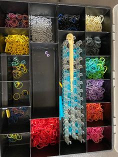 an assortment of different colored rubber bands in storage bins