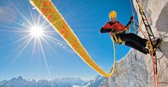 a man climbing up the side of a snow covered mountain