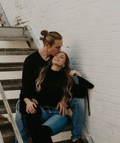 two women are sitting on the stairs and one is kissing the other's cheek