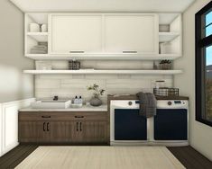 a white and brown kitchen with two washer dryers next to each other in front of a window