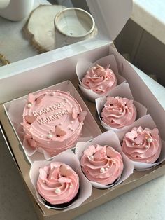 cupcakes with pink frosting and sprinkles in a box