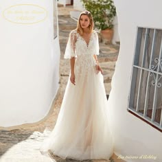 a woman in a white wedding dress standing on a cobblestone street with an open door