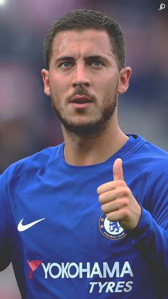 a soccer player giving the thumbs up sign with his right hand in front of him