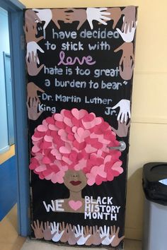 a door decorated with pink paper hearts and handprints on the front, saying i have decided to stick with love that is to great a burden to bear dr martin luther jr