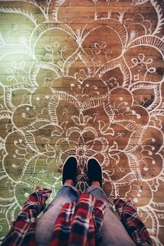 a person standing in front of a wall with an intricate design on the floor and walls