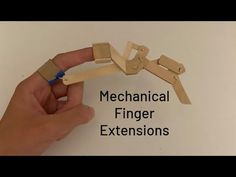 a hand holding a piece of wood with the words mechanical finger extensions