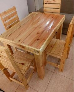 a table and chairs made out of wooden pallets in a room with tile flooring