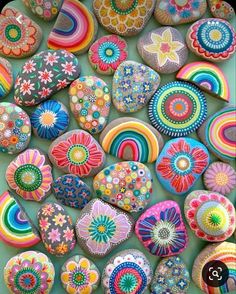 there are many different colored rocks on the table and one is painted with colorful colors