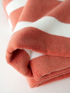 a red and white striped towel folded on top of each other with the end rolled up