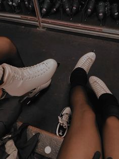 two people wearing white sneakers and black shorts are sitting on the ground with their legs crossed