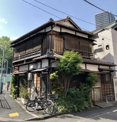 two bikes are parked in front of an old - fashioned building on the corner of a street