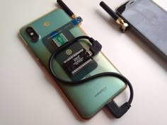 an electronic device is plugged into the back of a cell phone with a charger attached to it