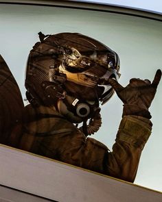 a man in a pilot's uniform is making the peace sign