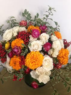 a vase filled with lots of different colored flowers