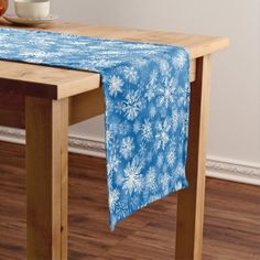 a table topped with a blue and green table cloth next to a bowl of fruit