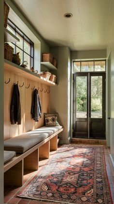 a hallway with a rug, coat rack and benches