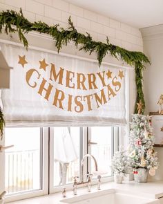 a christmas banner hanging over a kitchen sink