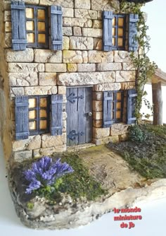 a house made out of rocks with blue shutters