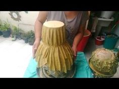 a woman is making a vase out of paper