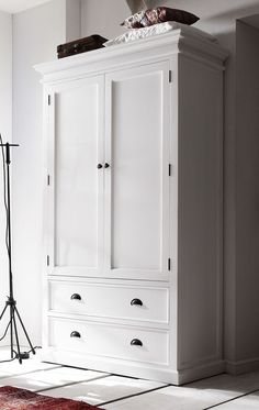 a white armoire with drawers in a room