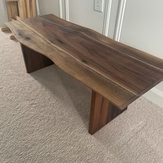 a wooden bench sitting on top of a carpeted floor