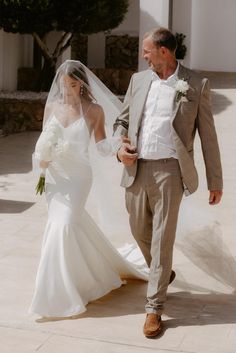 a bride and groom walking down the street