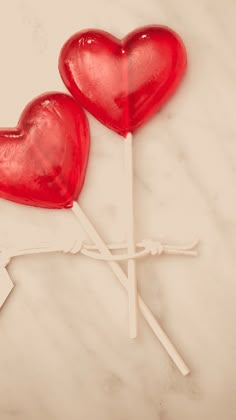 two heart shaped lollipops sitting on top of each other