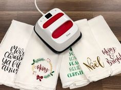 four white towels with christmas sayings on them and an electric hot plate in the middle